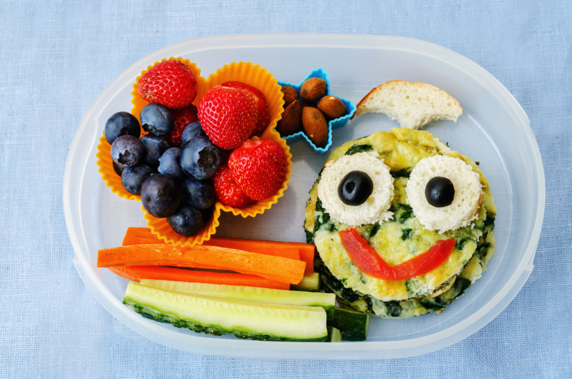 school lunch box for kids with food in the form of funny faces. 