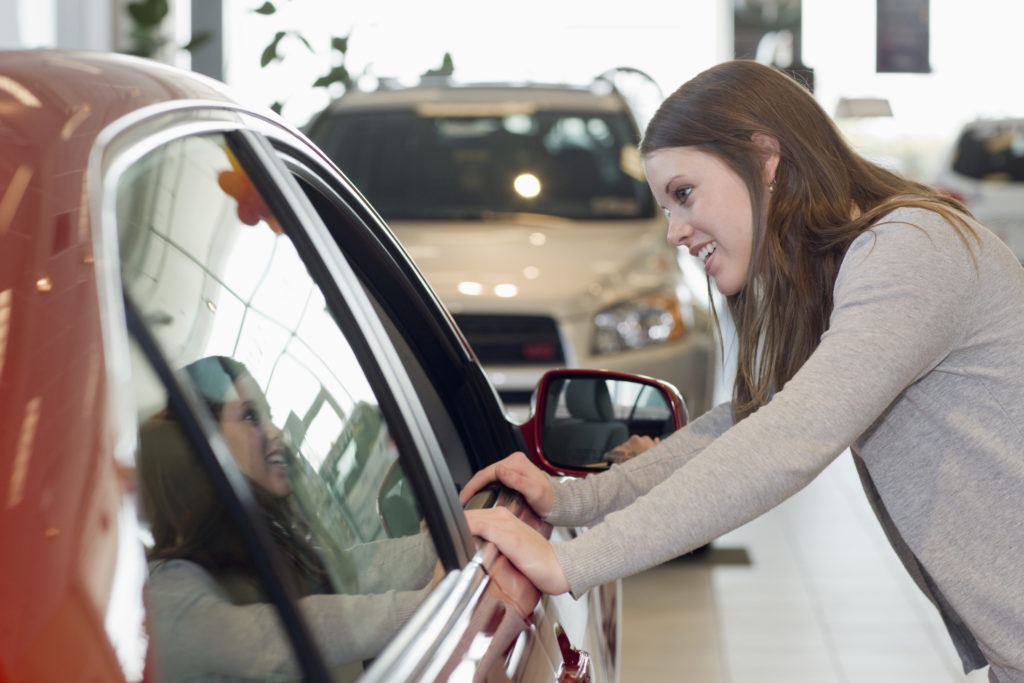 Young Woman Looking at a New Car