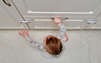 baby attempts to open a drawer that is child-proof
