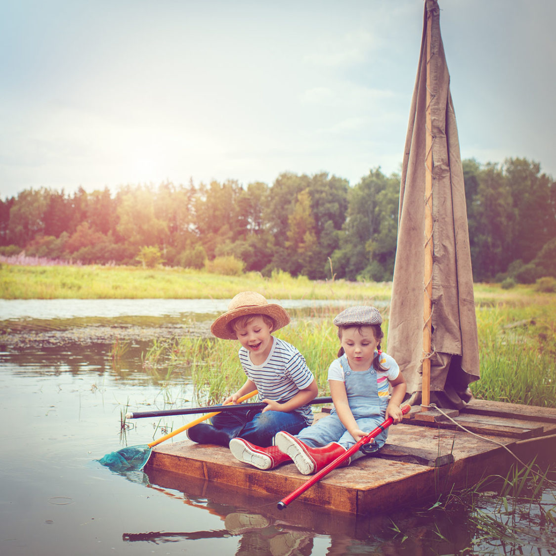 Deux enfants jouent à pêcher sur un radeau sur l'eau