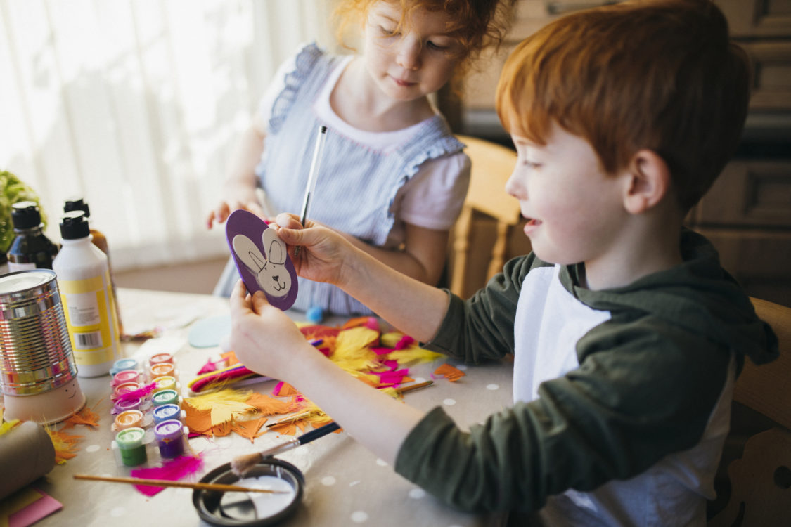 Deux enfants peignant et dessinant des arts et de l'artisanat de Pâques à la maison.
