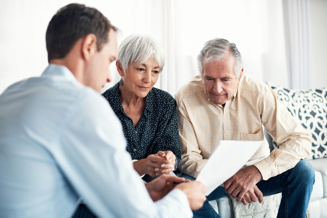 Plan d'un couple de personnes âgées recevant des conseils de leur conseiller financier à la maison