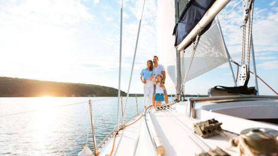 A family pictured relaxing on a yacht, enjoying a boat ride