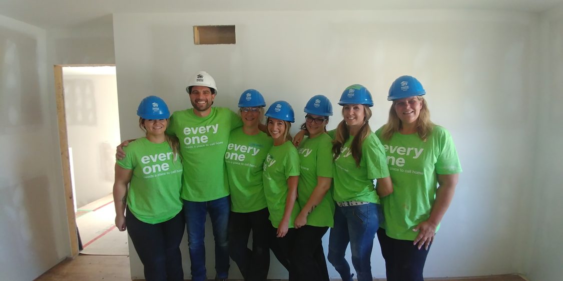 Image of Allstate Agents in green shirts volunteering with Habitat for Humanity