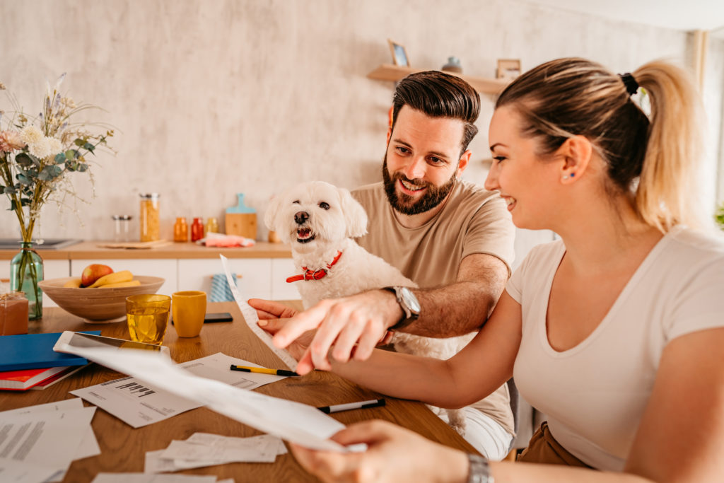Couple checking their finances at home with their dog