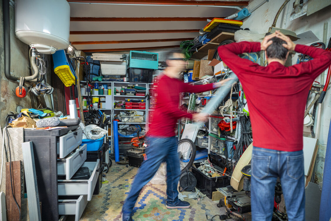 Image d’un homme essayant de réorganiser son garage pour le désencombrer. 