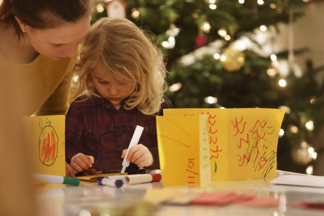 Jeune fille faisant des cartes de Noël faites maison