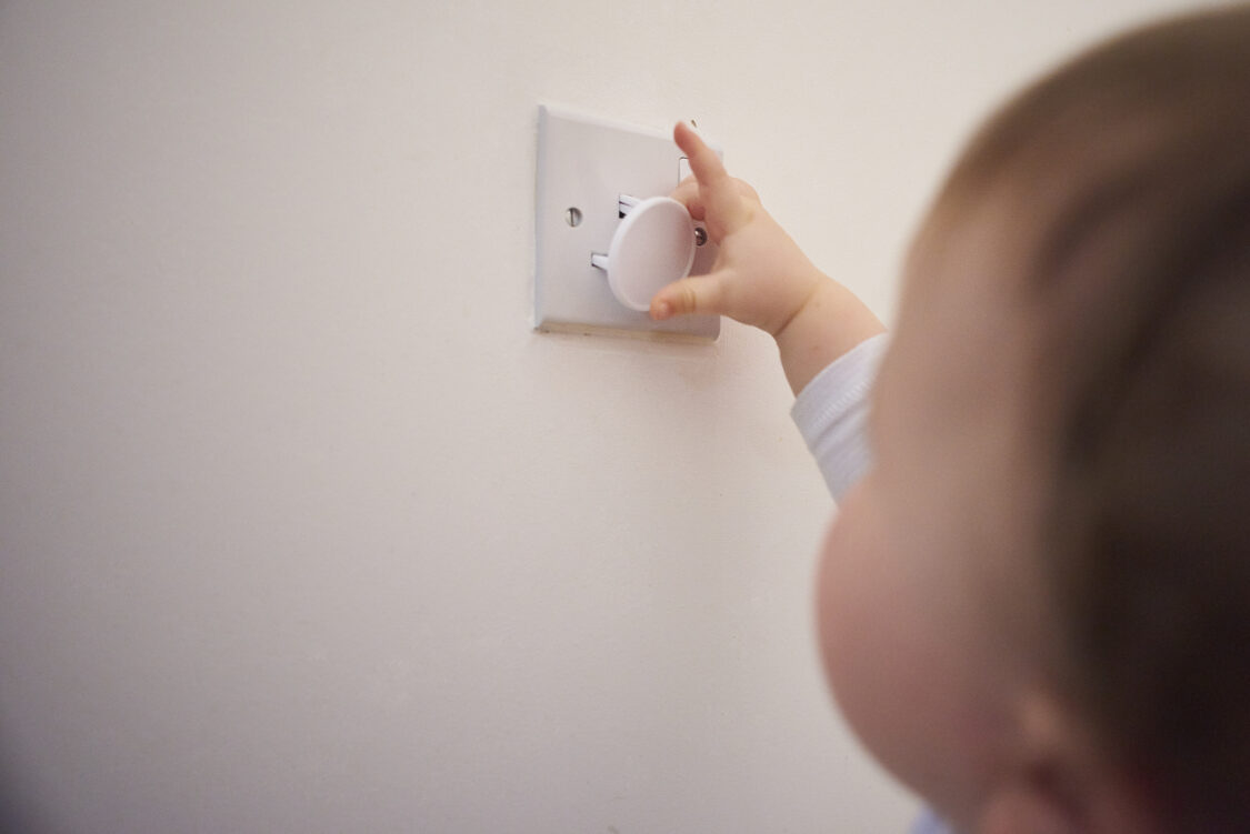 Toddler playing with plug socket