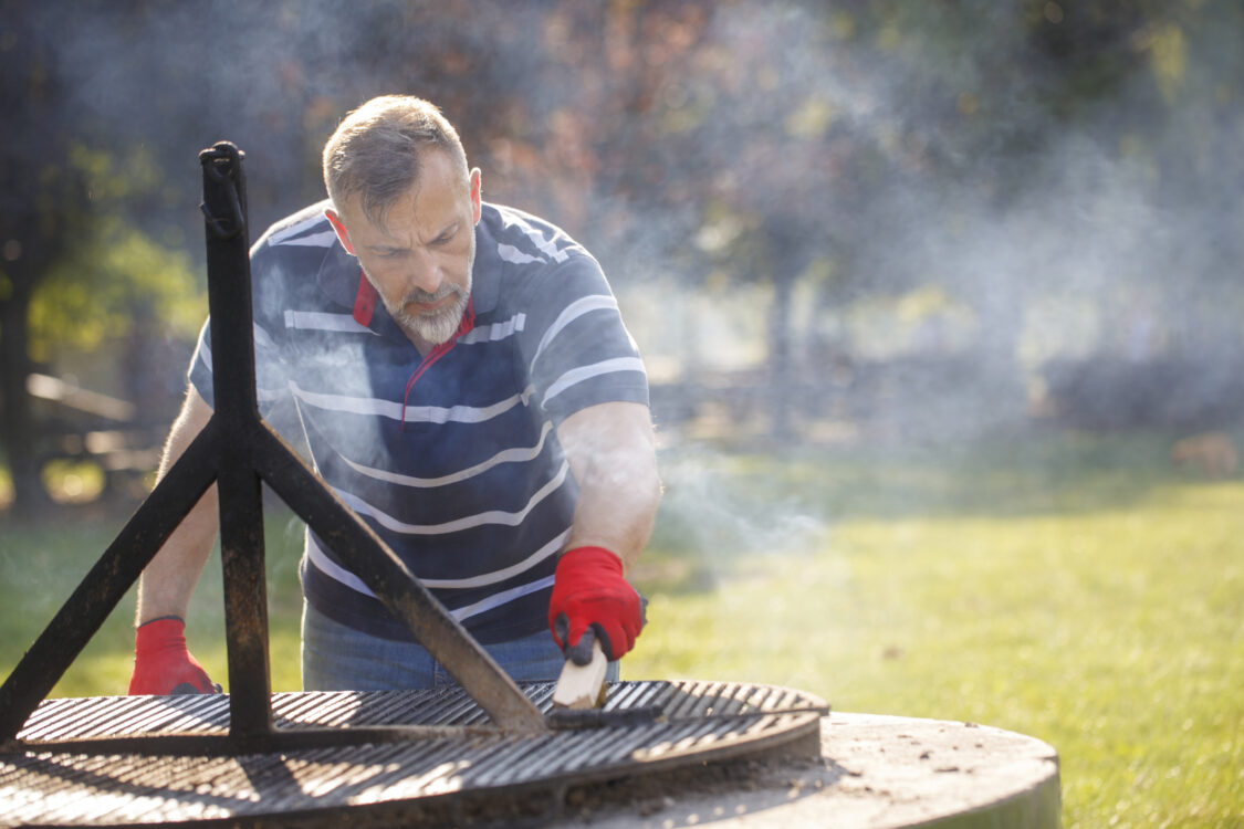 Homme nettoyant le barbecue