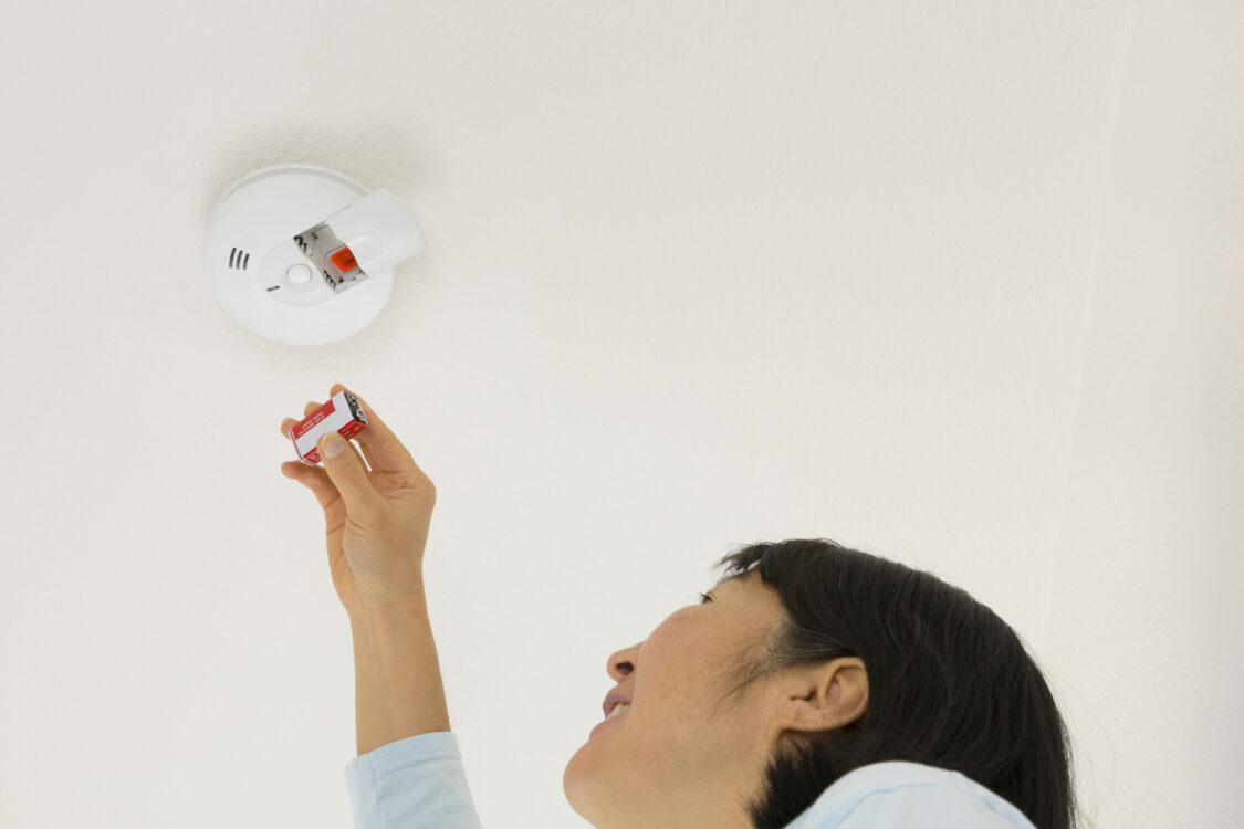 Woman inserting smoke alarm battery