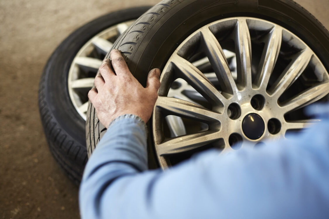 Garage mechanic examining car tire